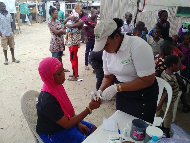 Nurse Abosede Elufowoju of Motus Health Initiative screening random blood glucose of beneficiaries at the Aboki estate Lekki Free Medical outreach.